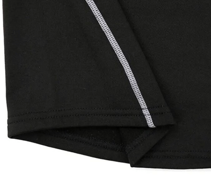 Close-up of the hem and stitching on a black women's sport long sleeve top, highlighting breathable and quick-dry fabric.